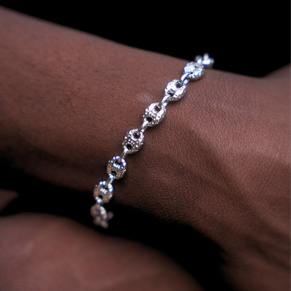 Silver bracelet on a wrist against a dark background