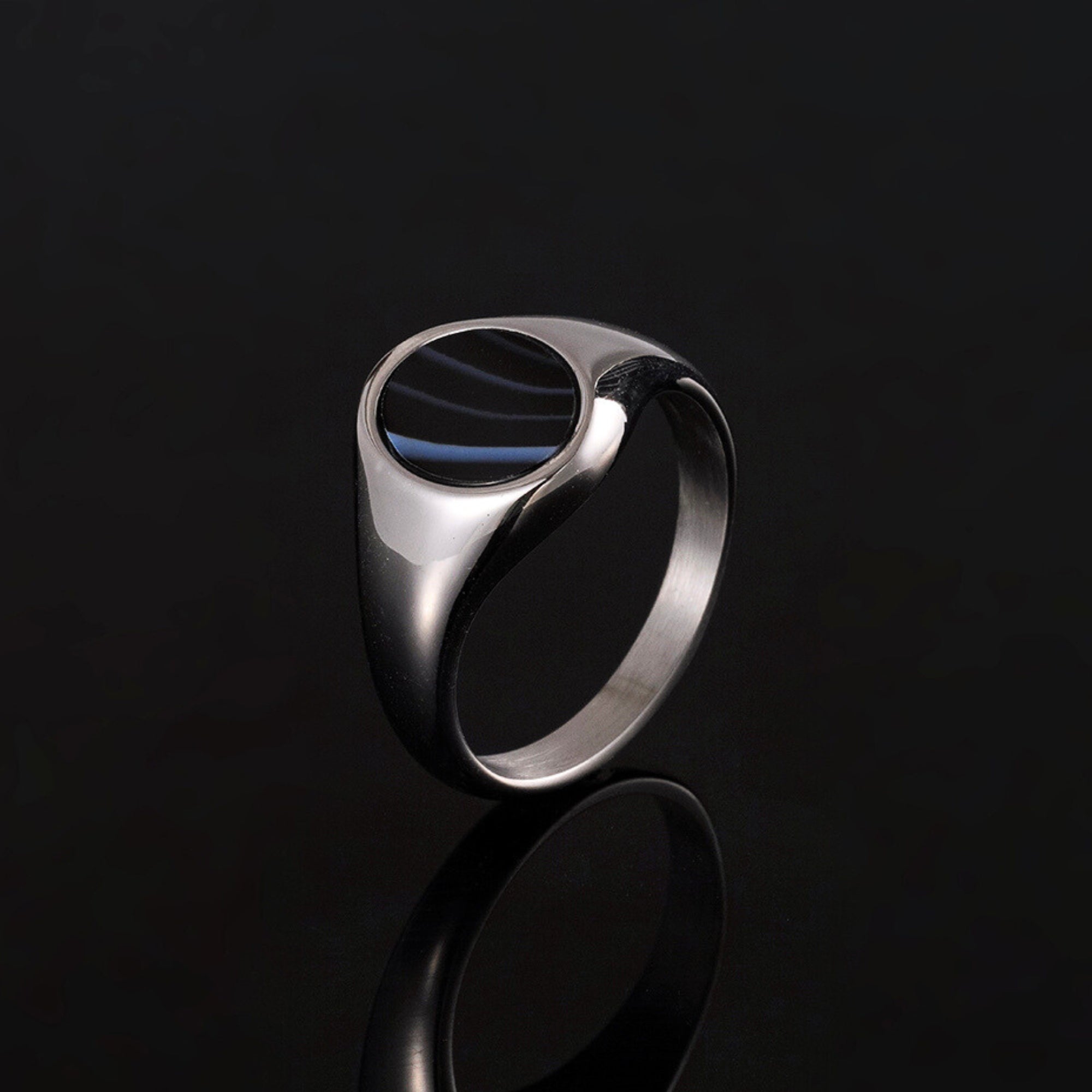 Silver ring with a black stone on a black background
