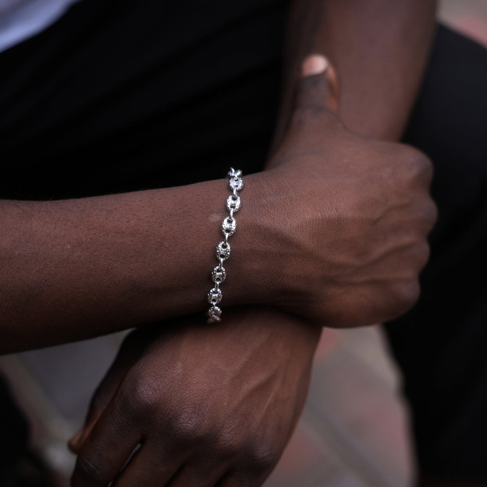 Close-up of a person's wrist wearing a silver bracelet with a blurred background