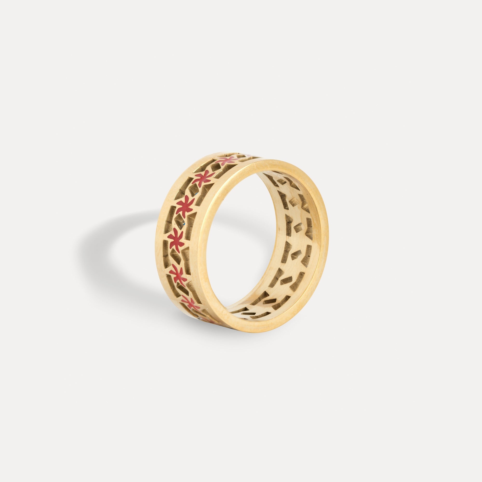 Gold ring with floral design on a light gray background