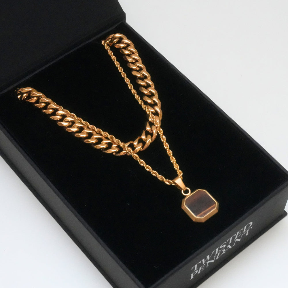 Gold chain necklace with a pendant on a branded black box