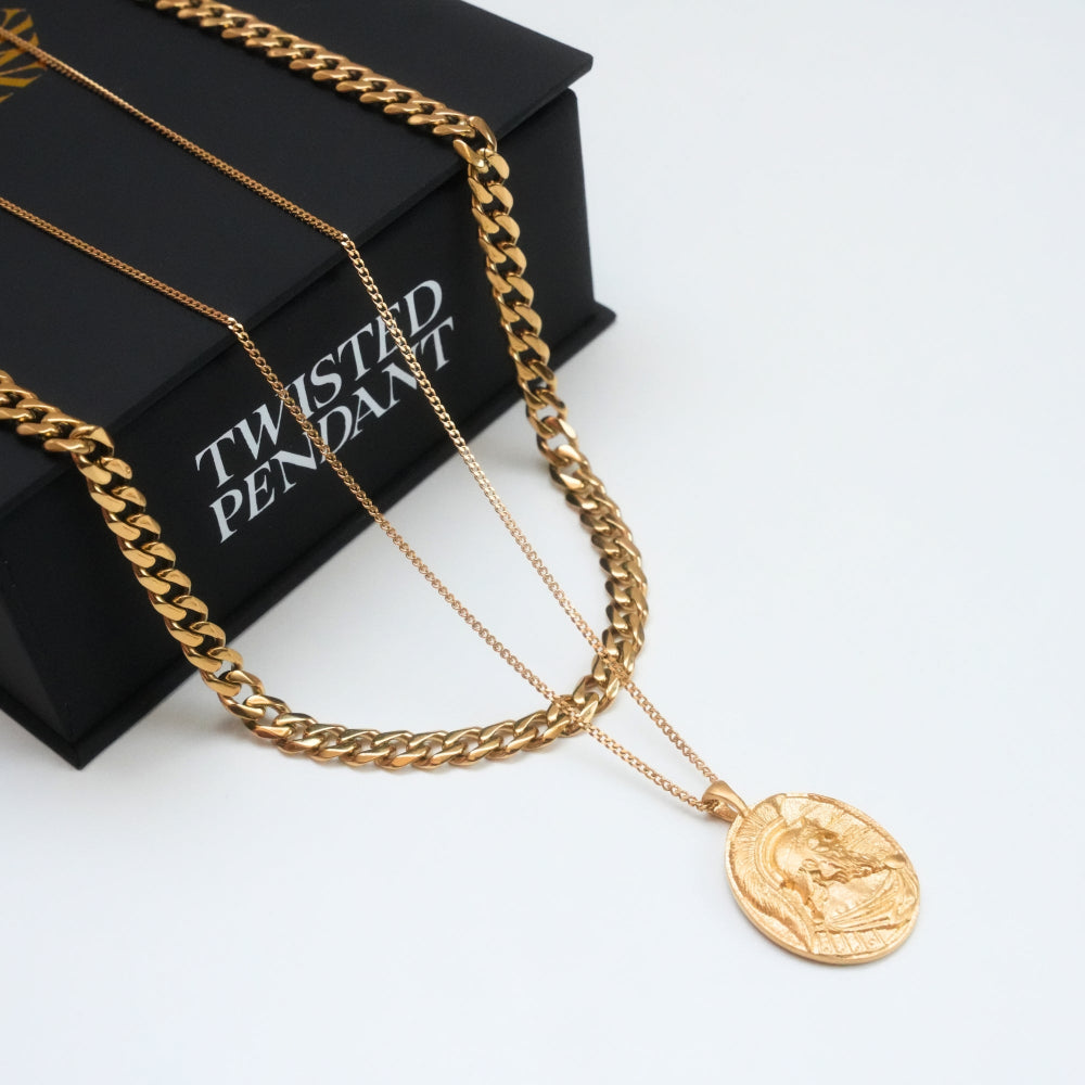 Gold chain necklace with a pendant on a black box labeled 'Twisted Pendant'.