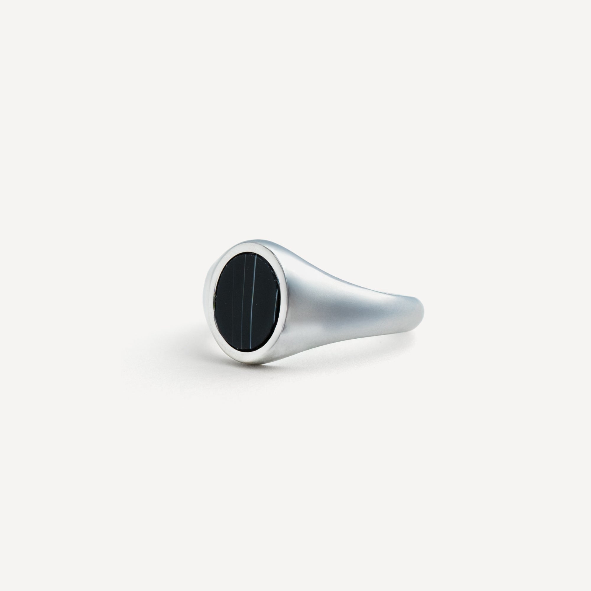 Silver ring with a black stone on a white background