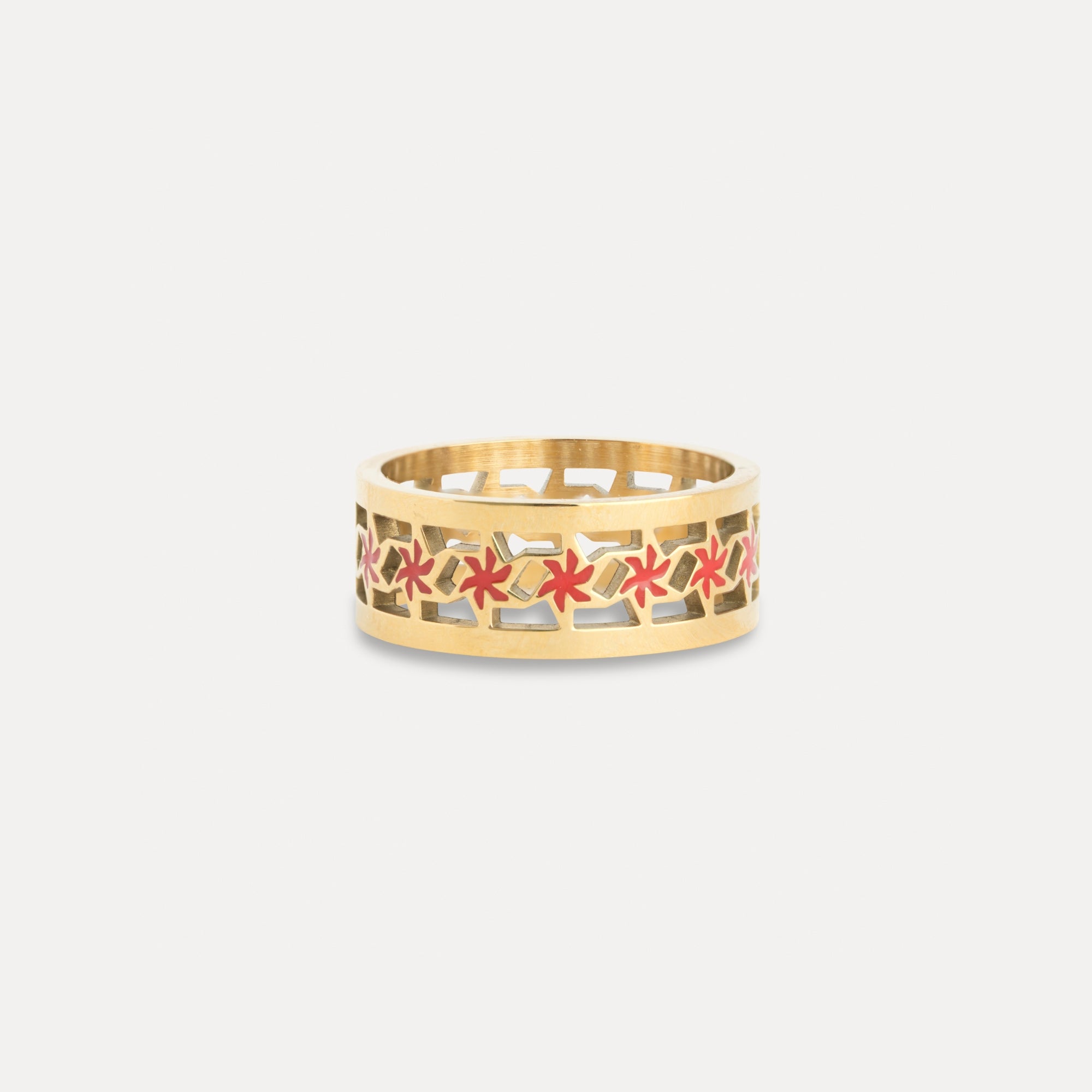 Gold ring with red floral patterns on a white background