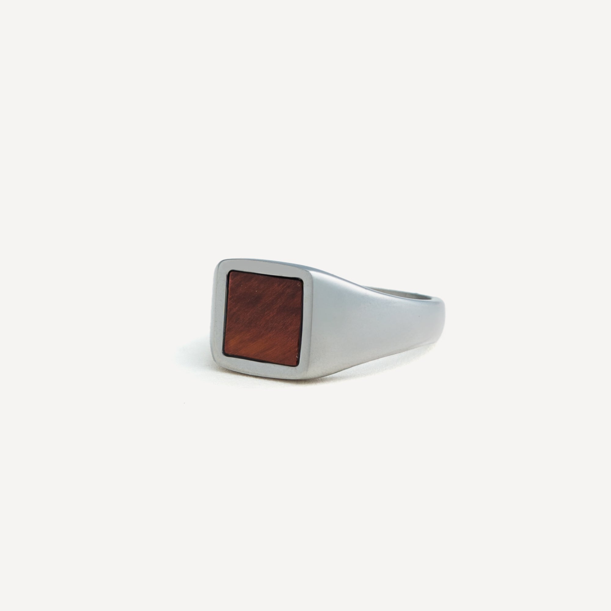Silver ring with a wooden inlay on a white background