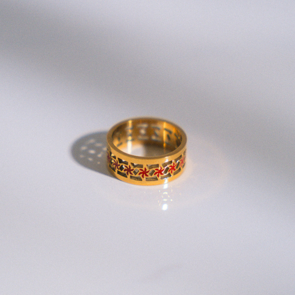 Gold ring with decorative pattern on a white background