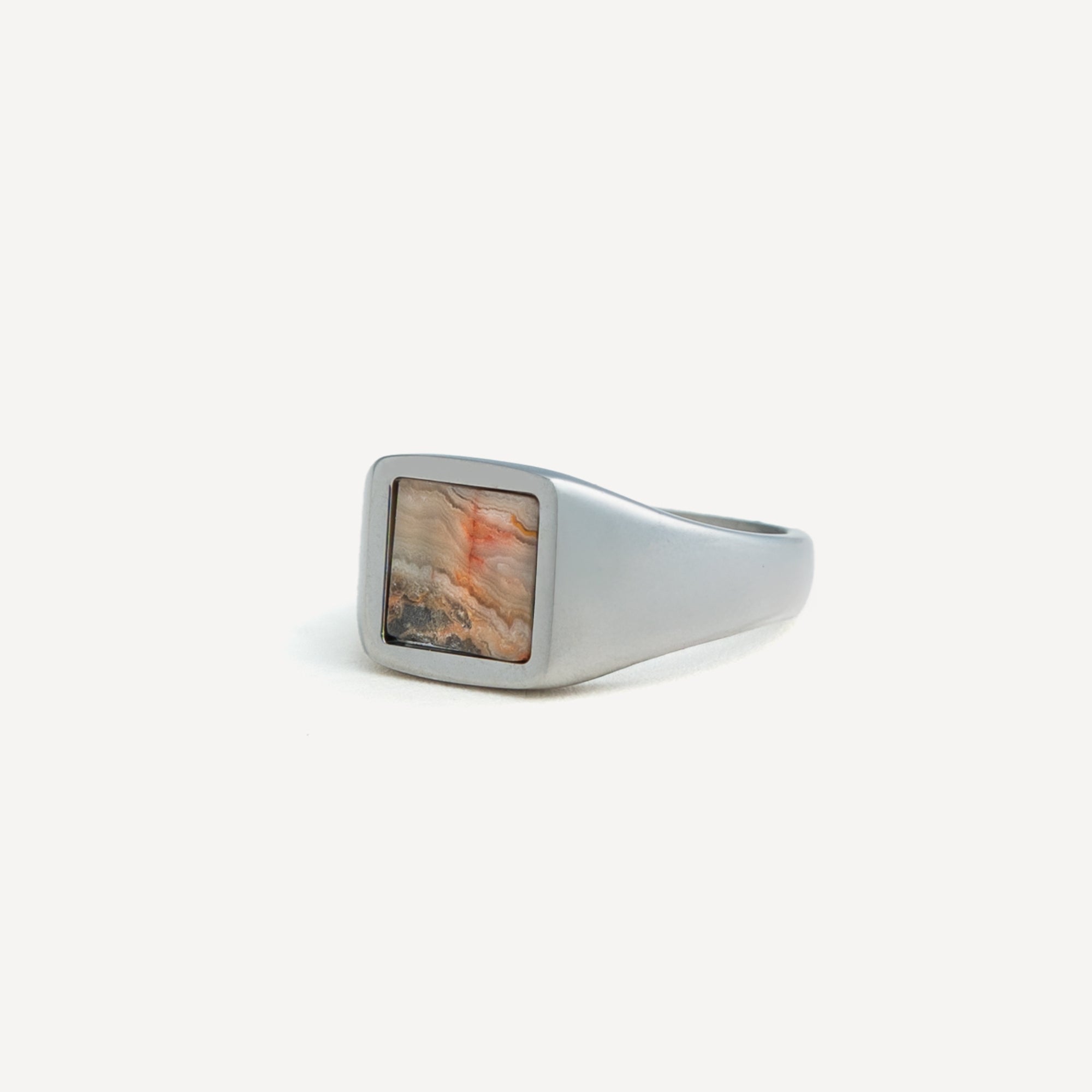 Silver ring with a square stone on a white background