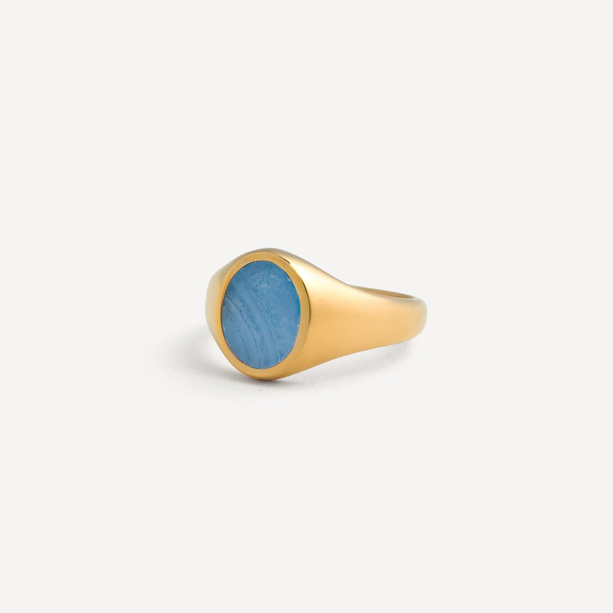 Gold ring with a blue stone on a white background