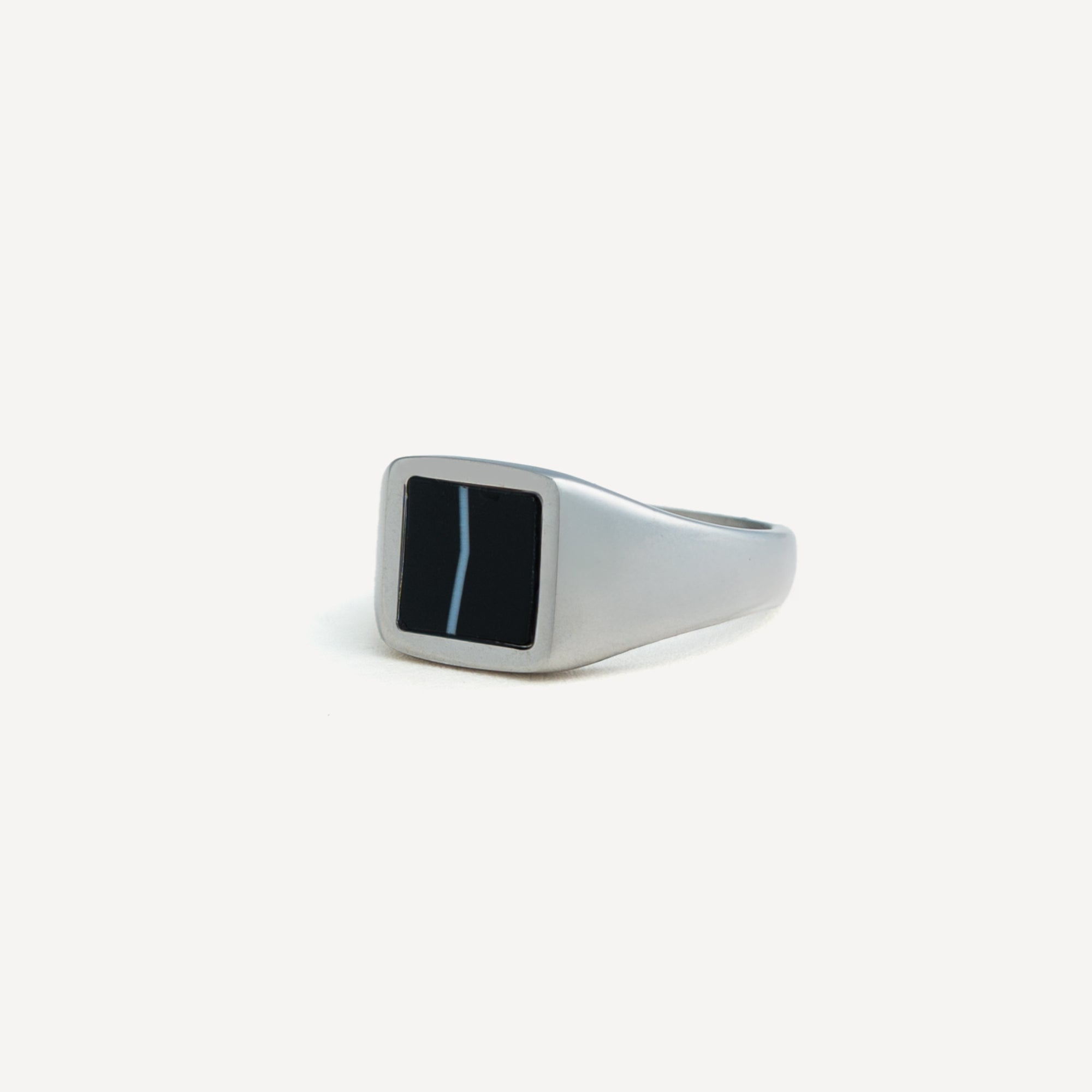 Silver ring with a black stone on a white background