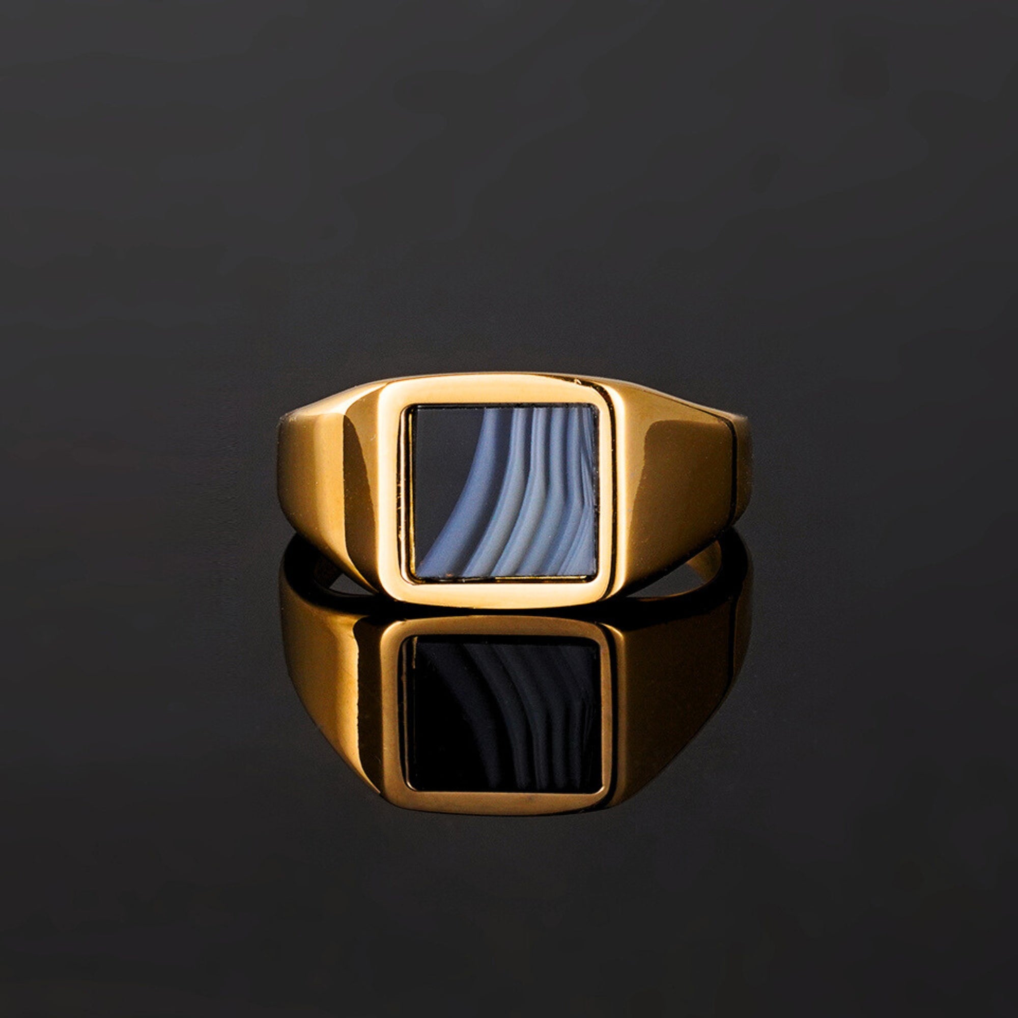 Gold ring with a blue stone on a black background