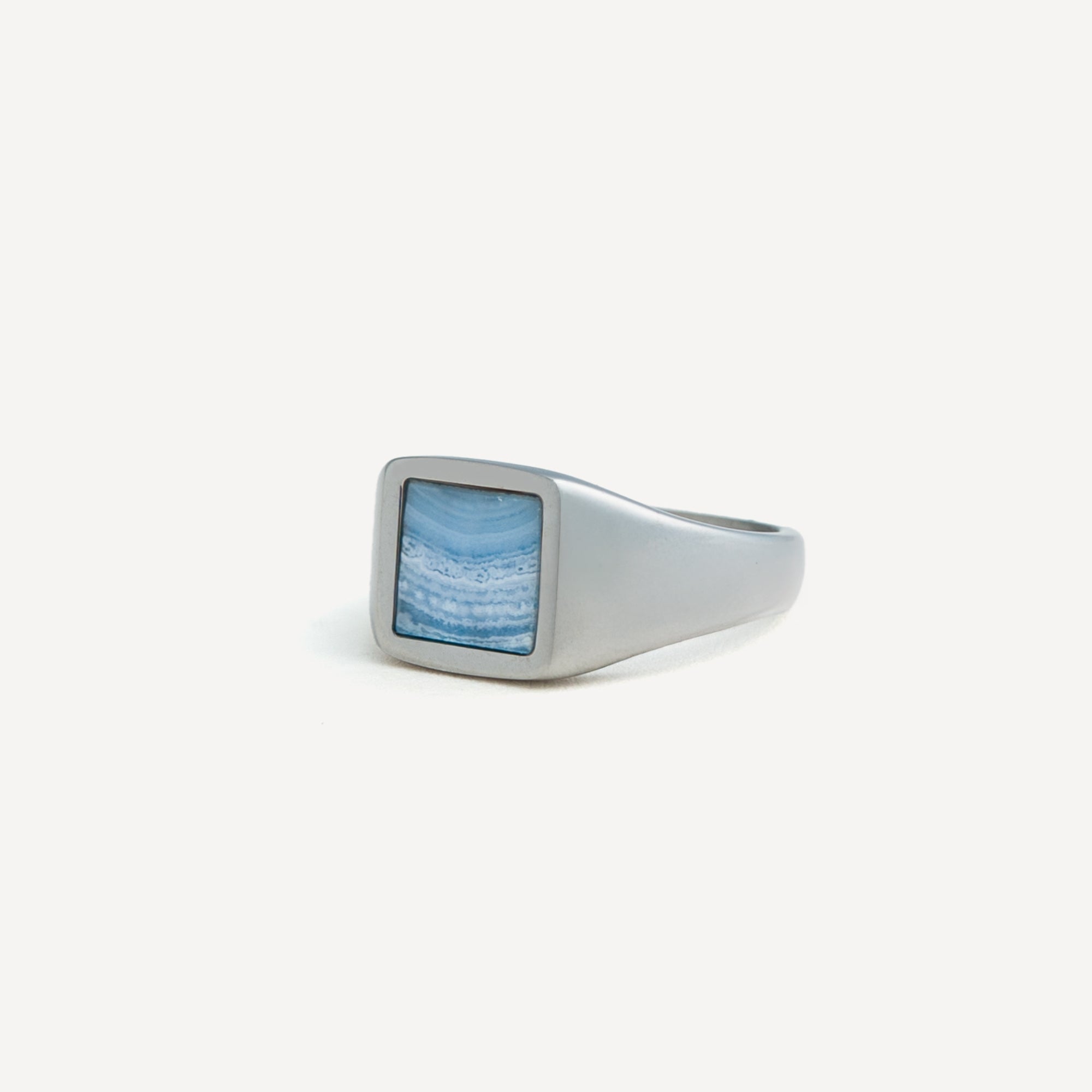 Silver ring with a blue stone on a white background