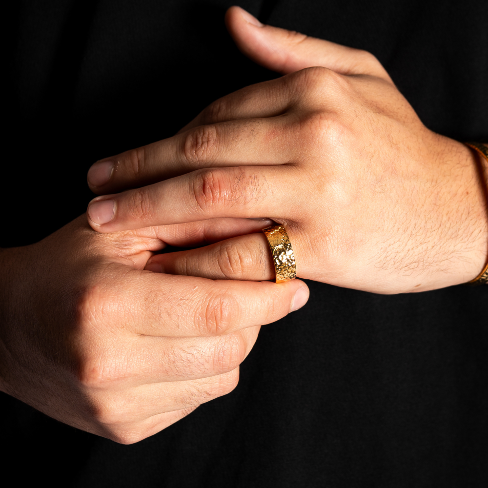 Close-up of hands with a gold ring on a black background