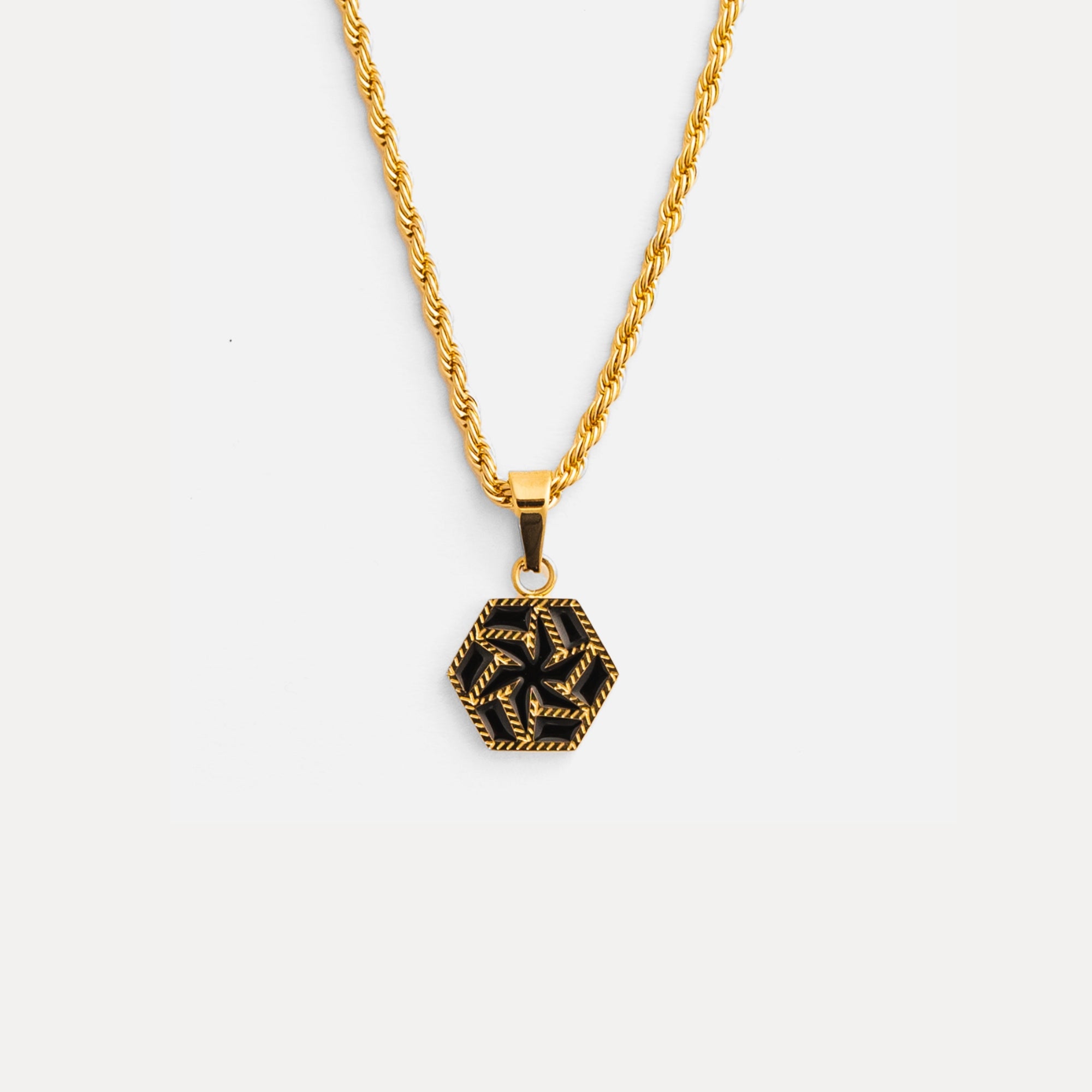 Gold necklace with a black geometric pendant on a white background