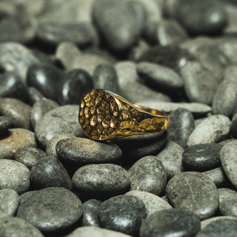 Gold ring on a bed of gray stones