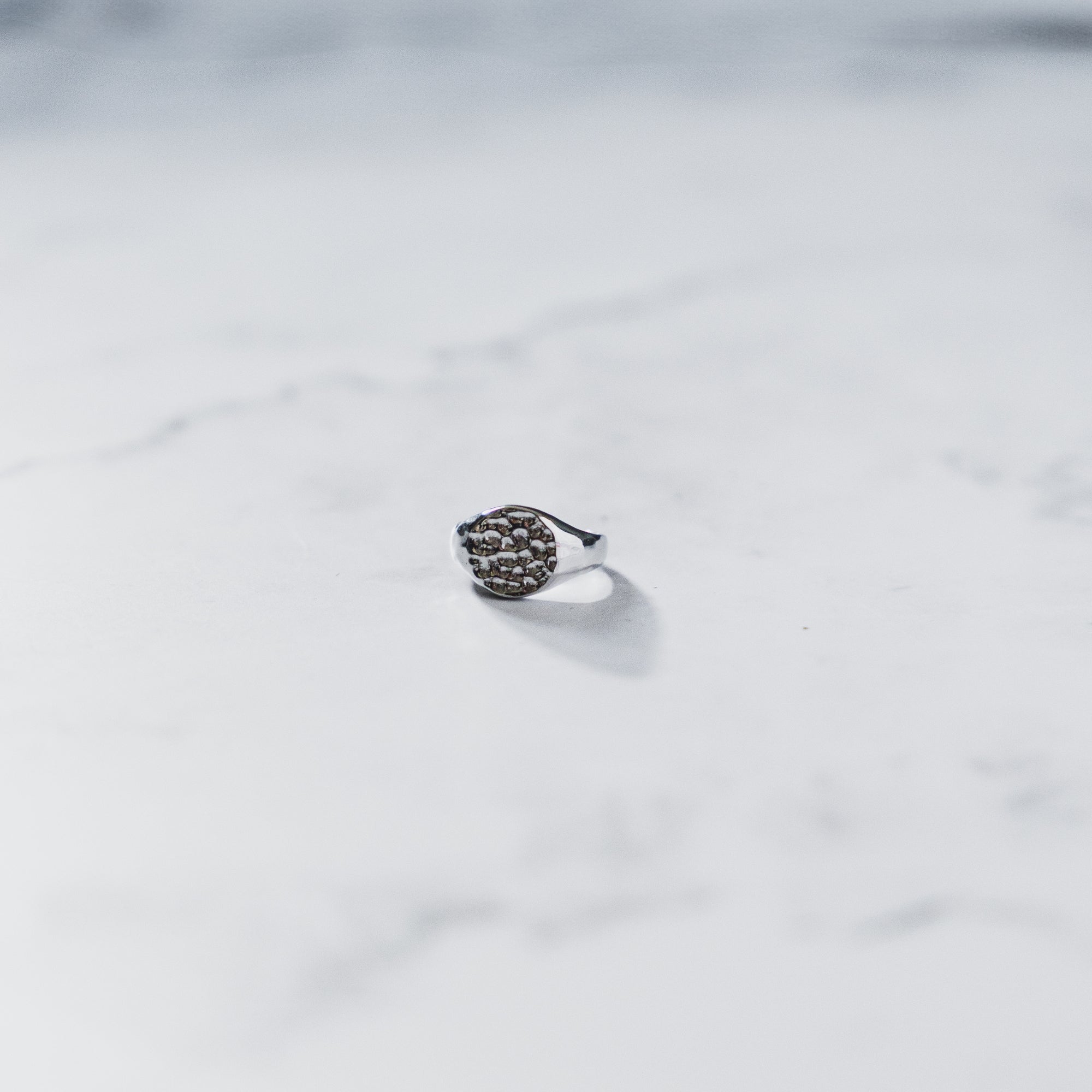 Silver ring with black stones on a white fabric background