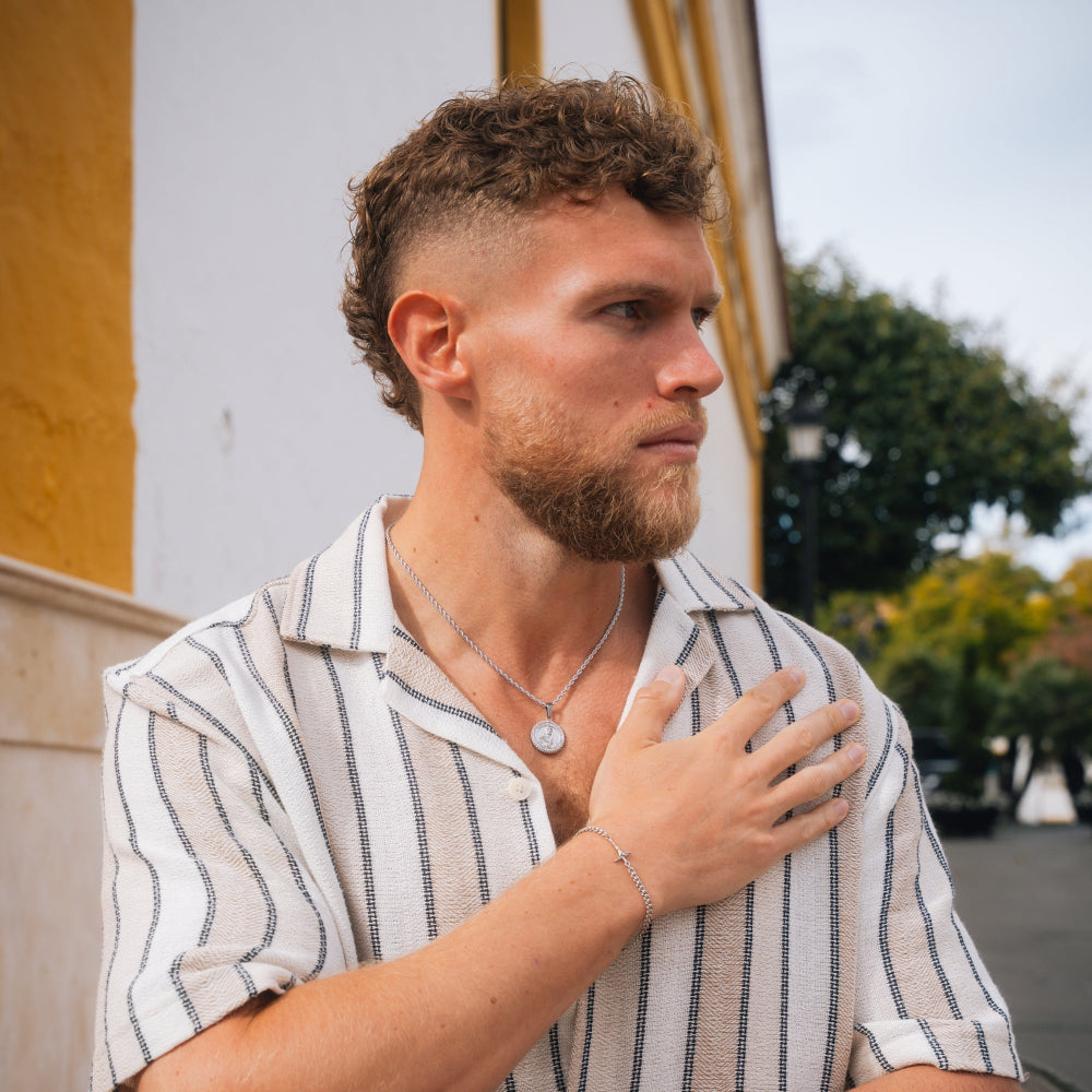 Man with a beard wearing a striped shirt outdoors