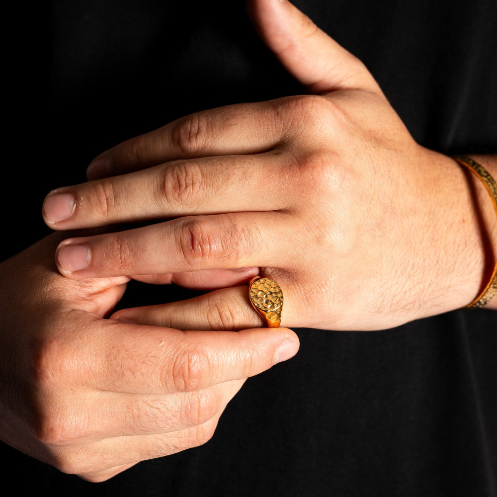 Close-up of hands with a gold ring on a black background