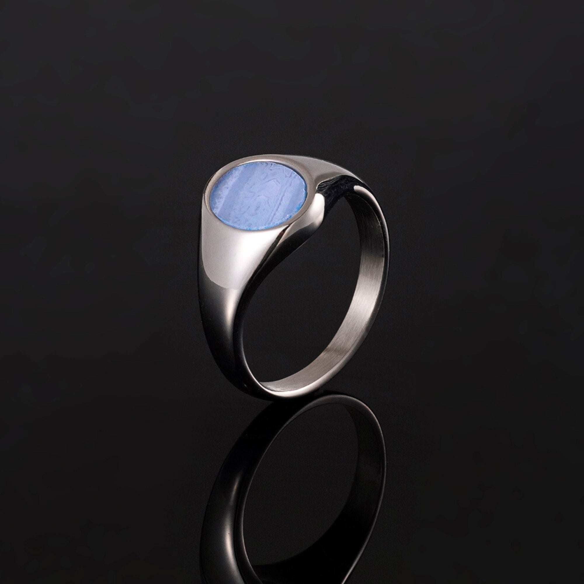 Silver ring with a blue stone on a black background