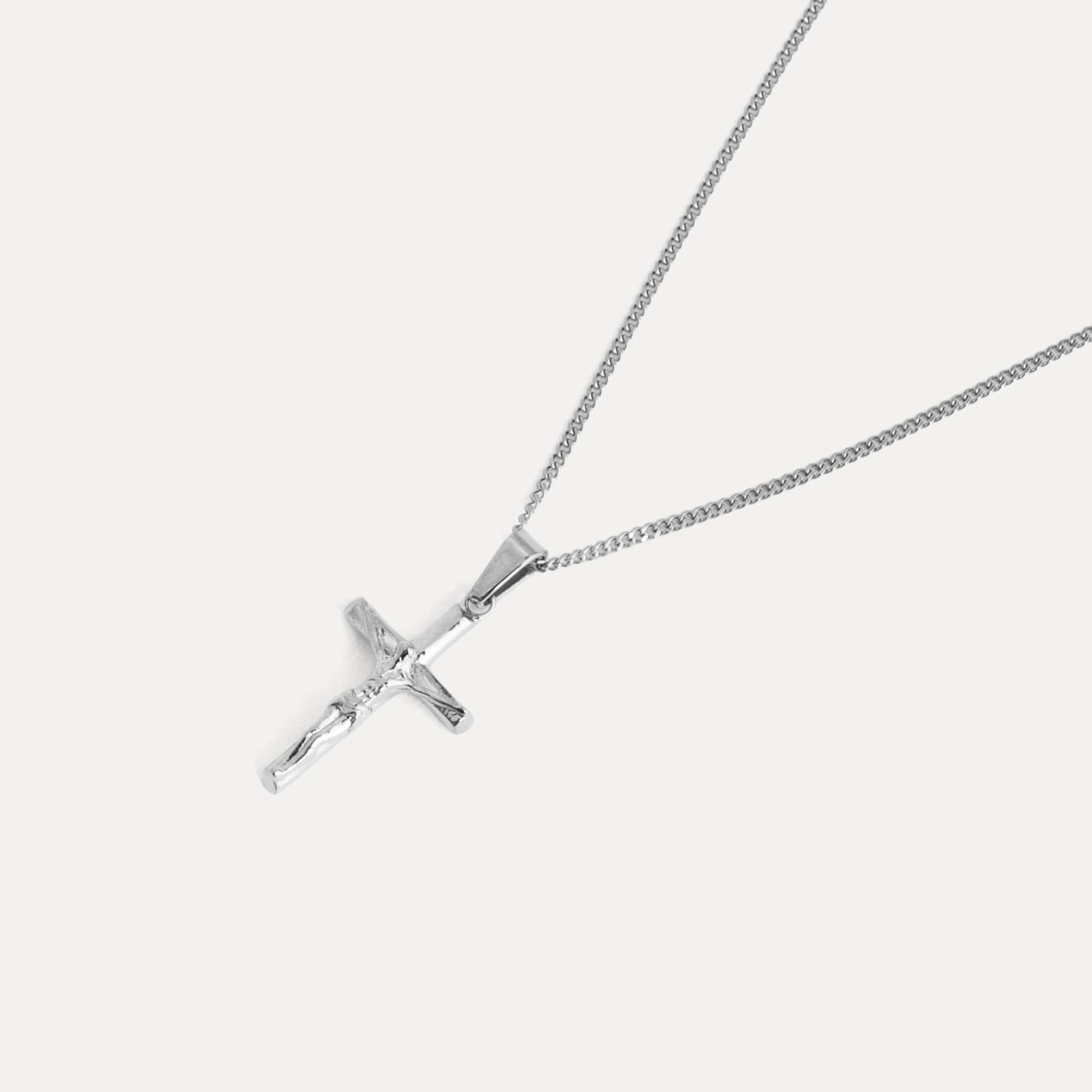 Silver cross pendant on a chain against a white background