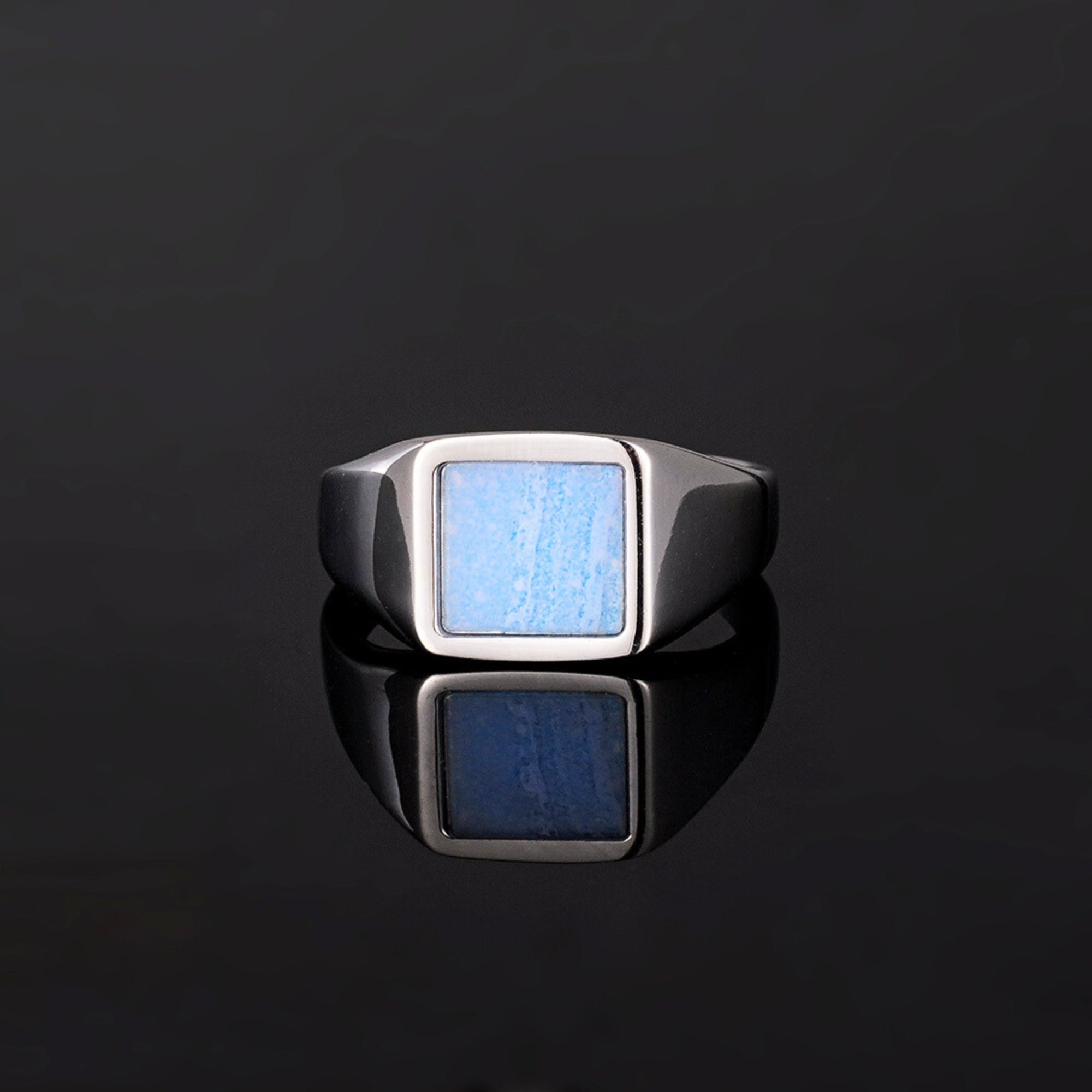 Silver ring with a blue stone on a black background