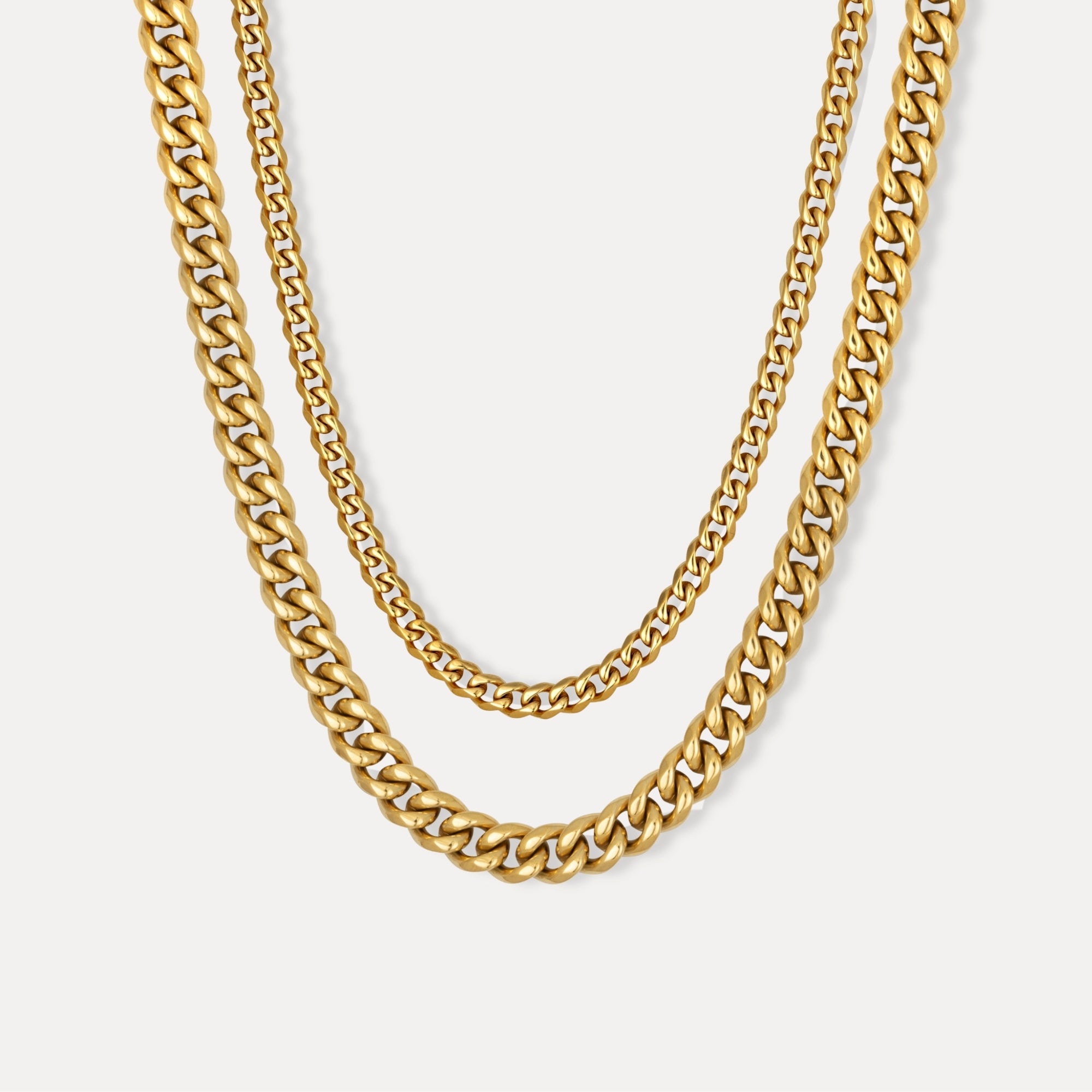 Gold chain necklace on a light gray background
