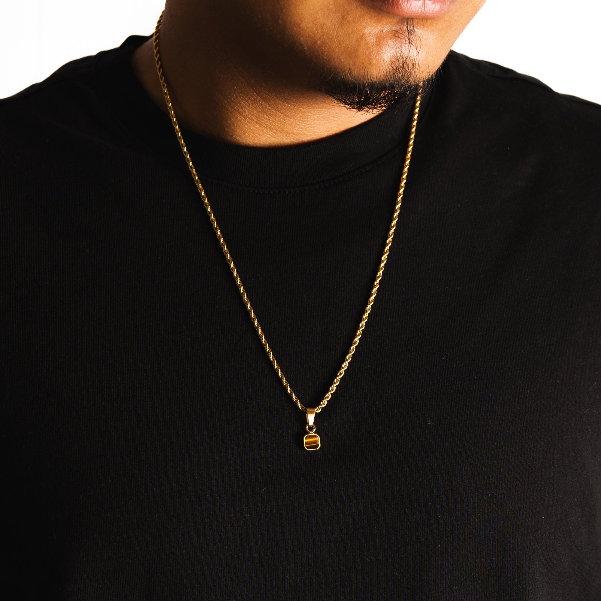 Gold necklace with a pendant on a black shirt