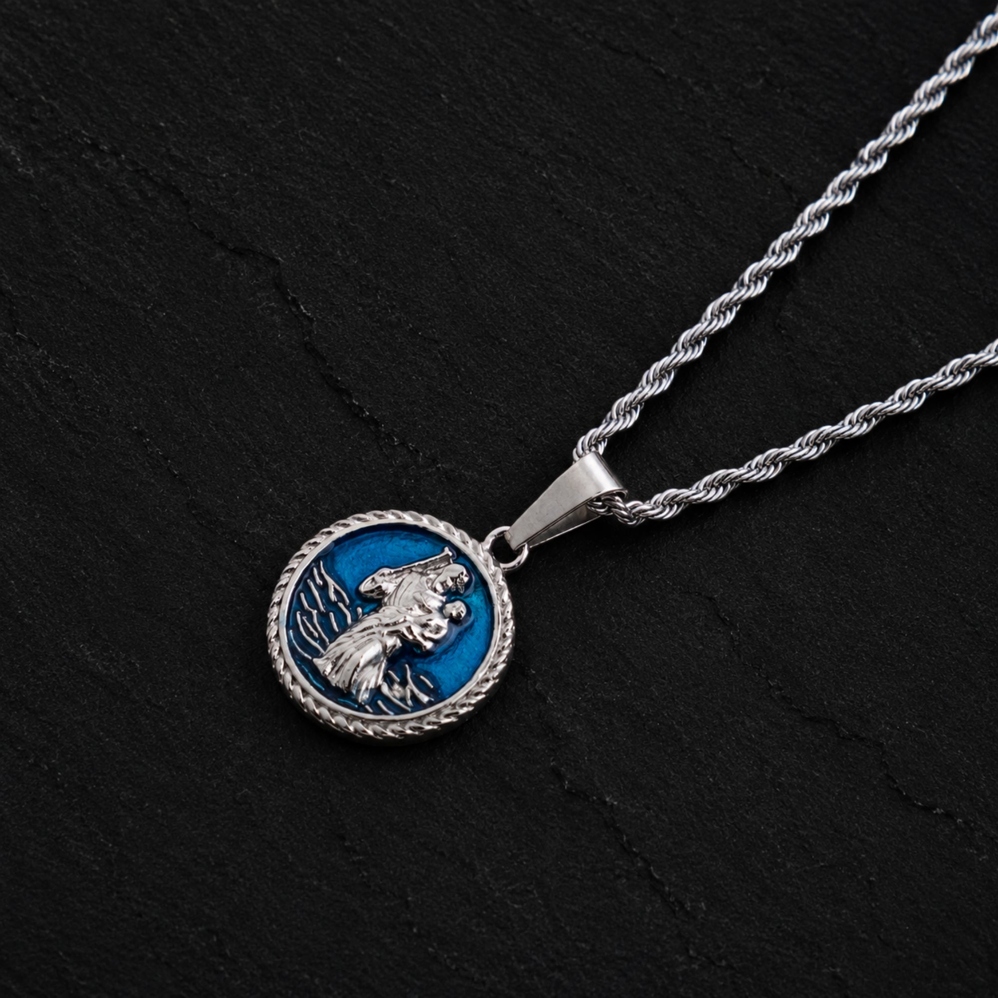 Silver necklace with a round pendant featuring a blue background and a bird design on a black background