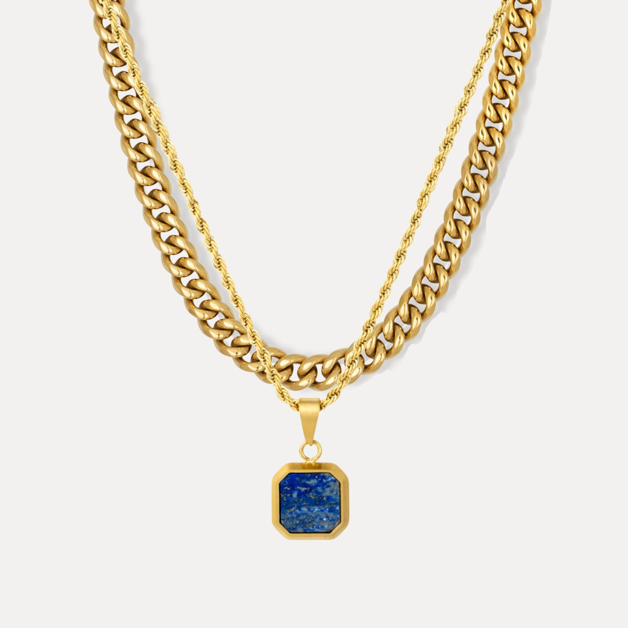 Gold chain necklace with a blue pendant on a white background