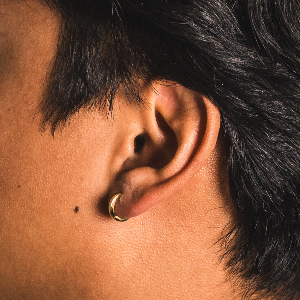 Close-up of an ear with a gold hoop earring