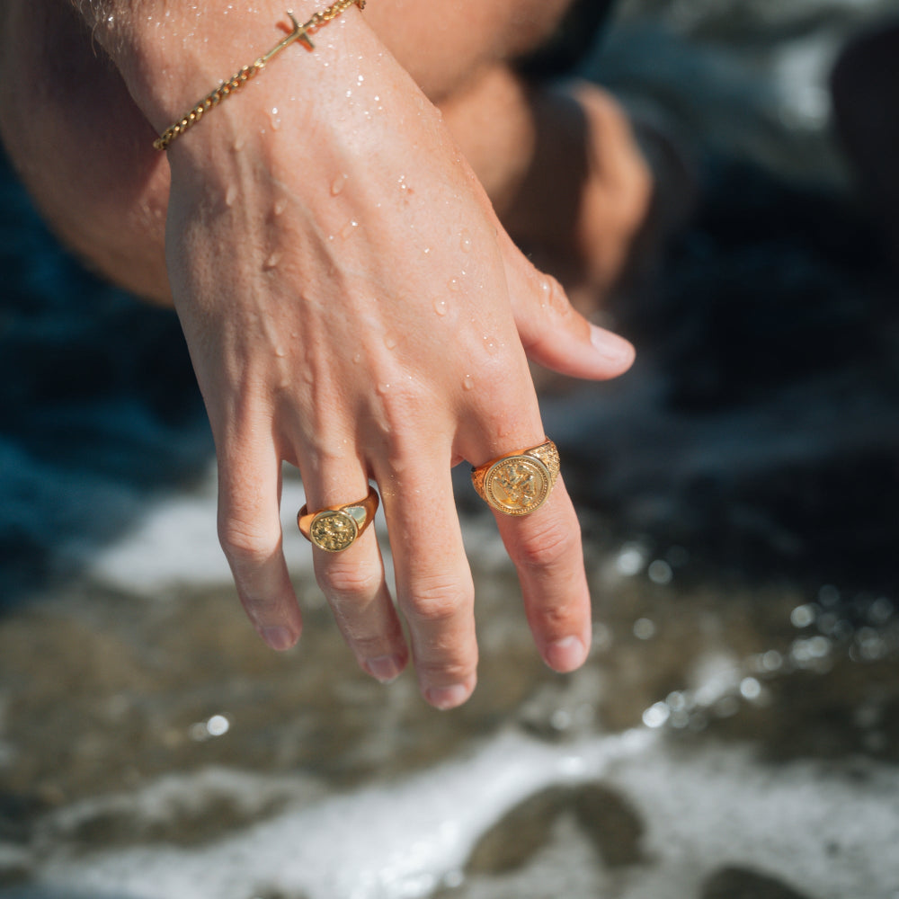 Close-up of hands with gold rings by a water source