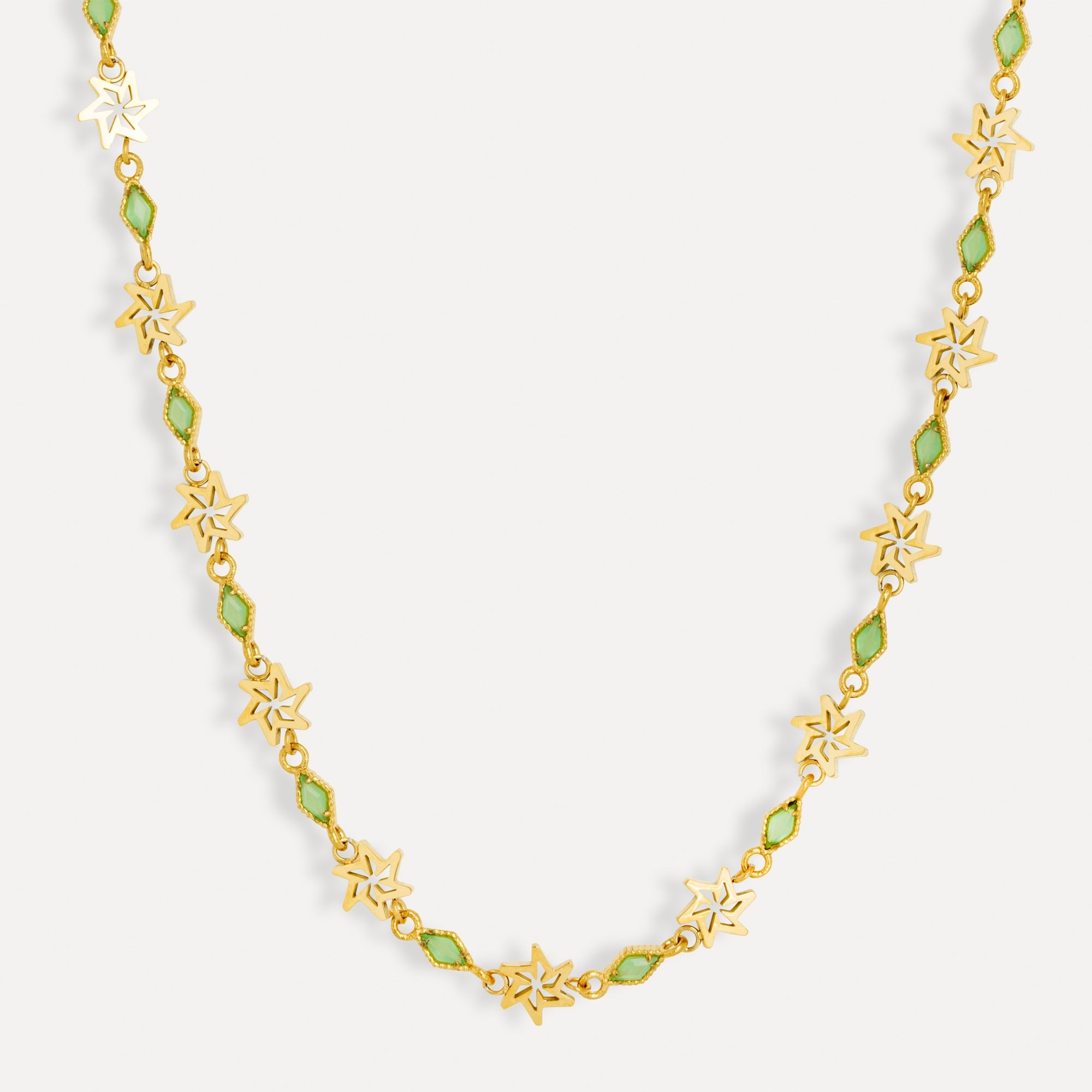 Gold necklace with star-shaped flowers and green beads on a white background