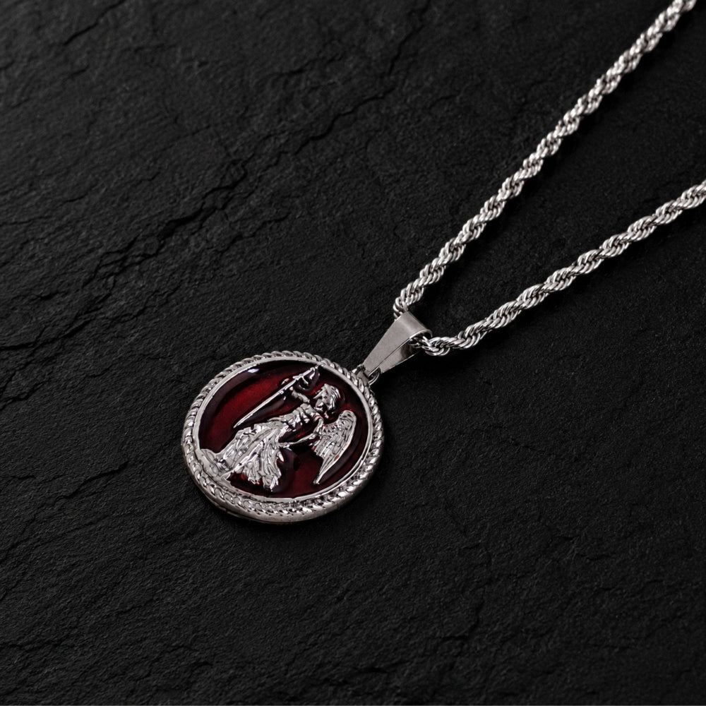 Silver necklace with a circular pendant featuring a design on a dark stone background
