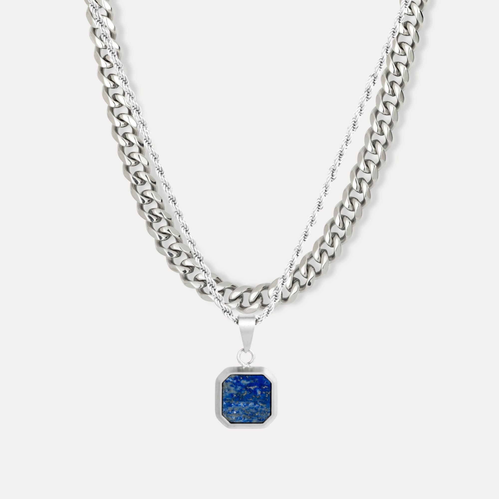 Silver chain necklace with a blue pendant on a white background