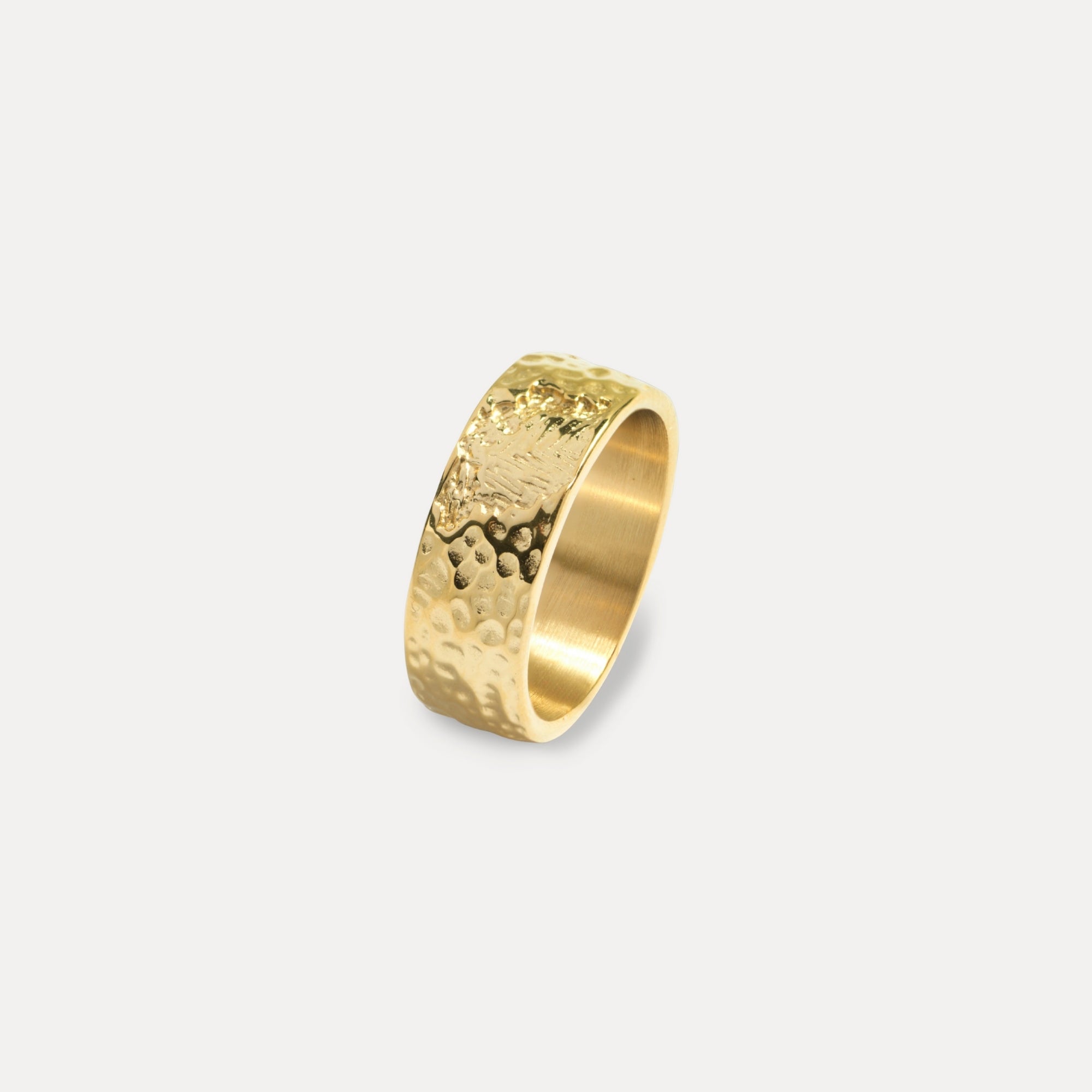 Gold ring with a textured design on a light gray background