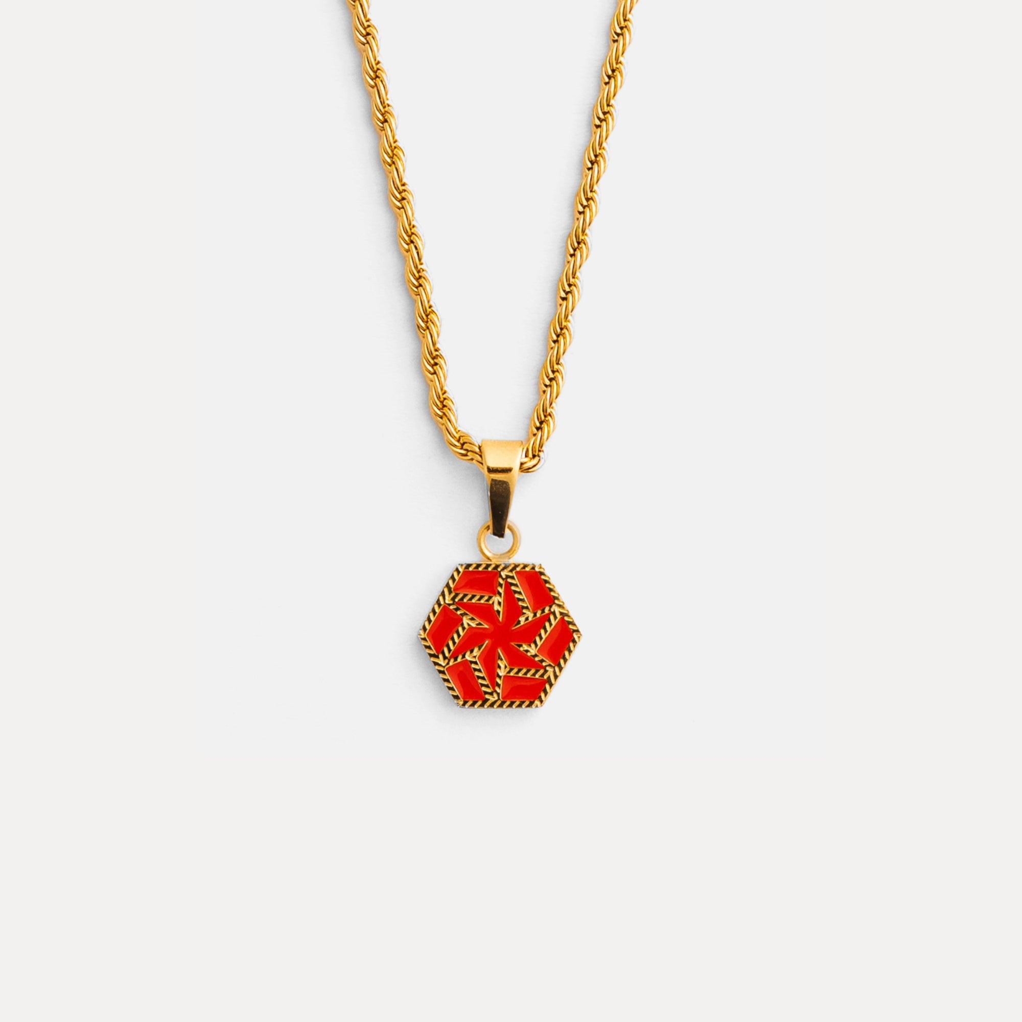 Gold necklace with a red and gold pendant on a white background