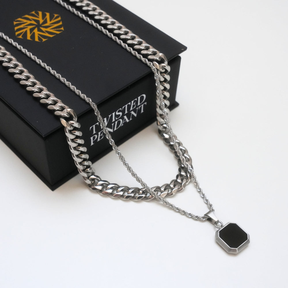 Silver chain necklace with a black pendant on a black box labeled 'Twisted Pendant'.