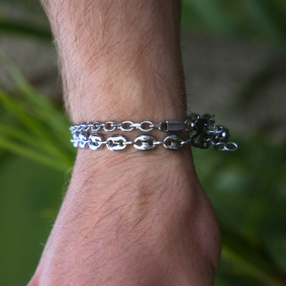 Silver chain bracelet on a wrist with a blurred natural background