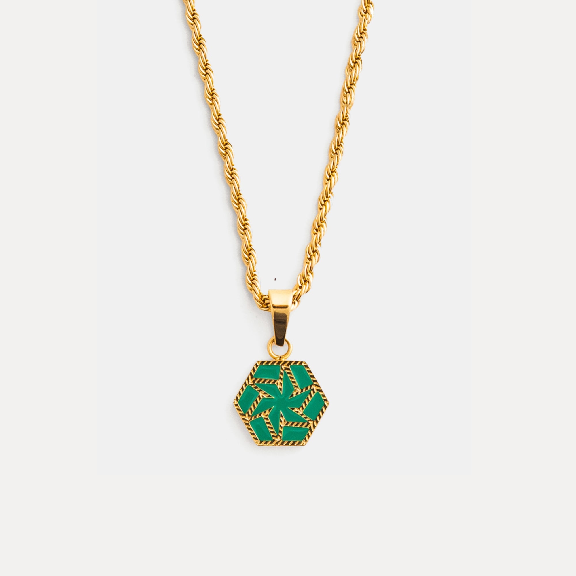 Gold necklace with a green hexagonal pendant on a white background