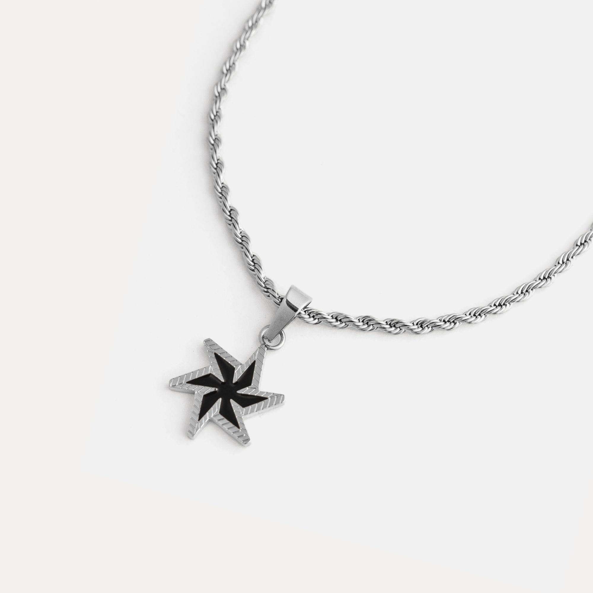 Star-shaped pendant on a chain against a white background