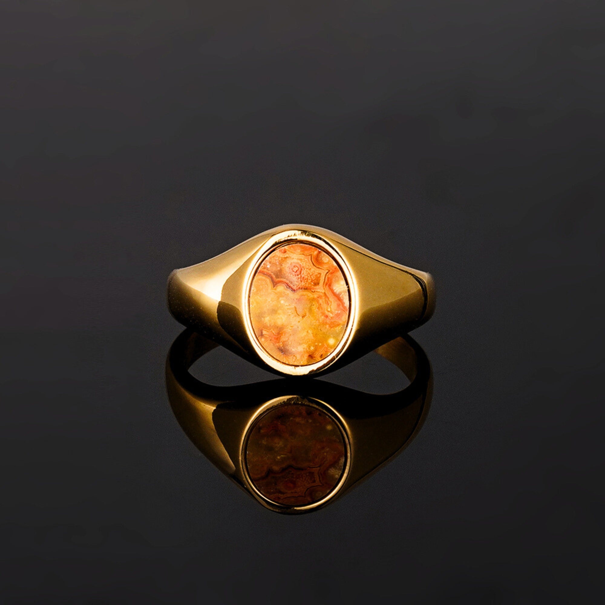 Gold ring with a amber-colored stone on a black background