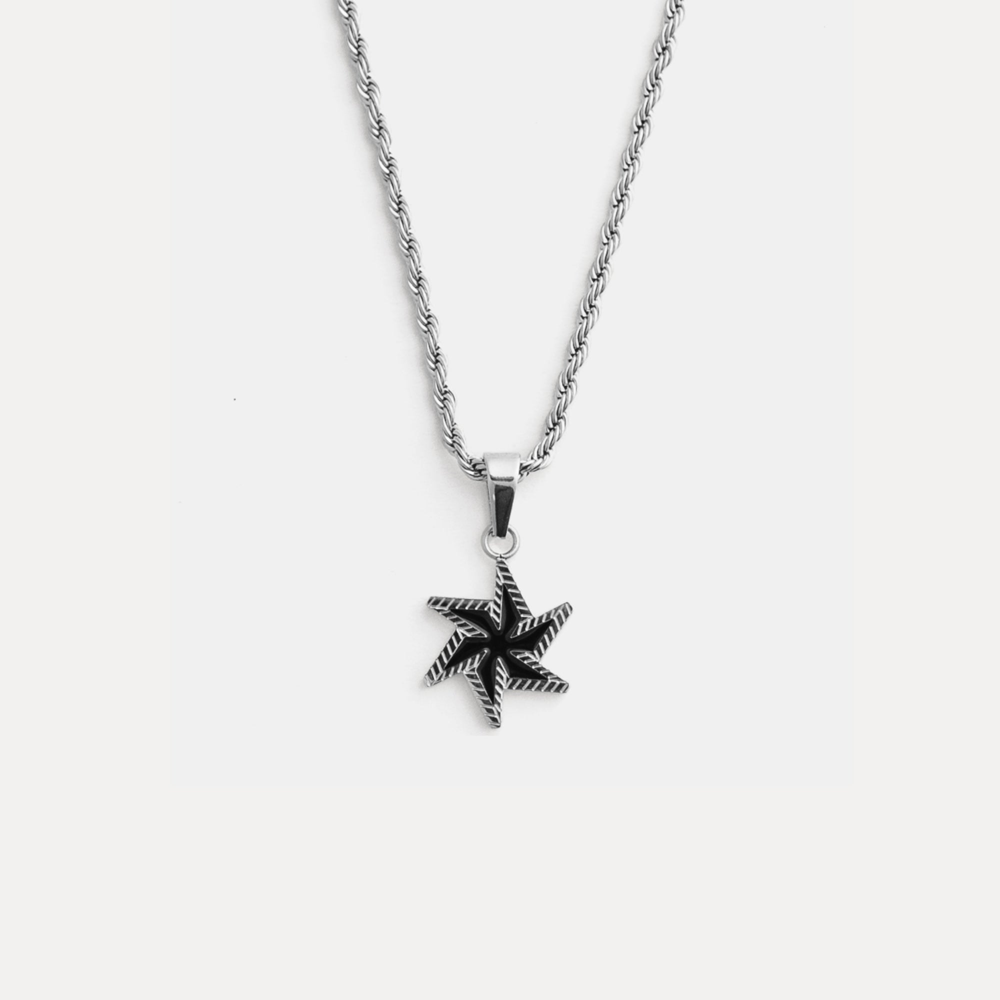 Star-shaped pendant on a chain against a white background