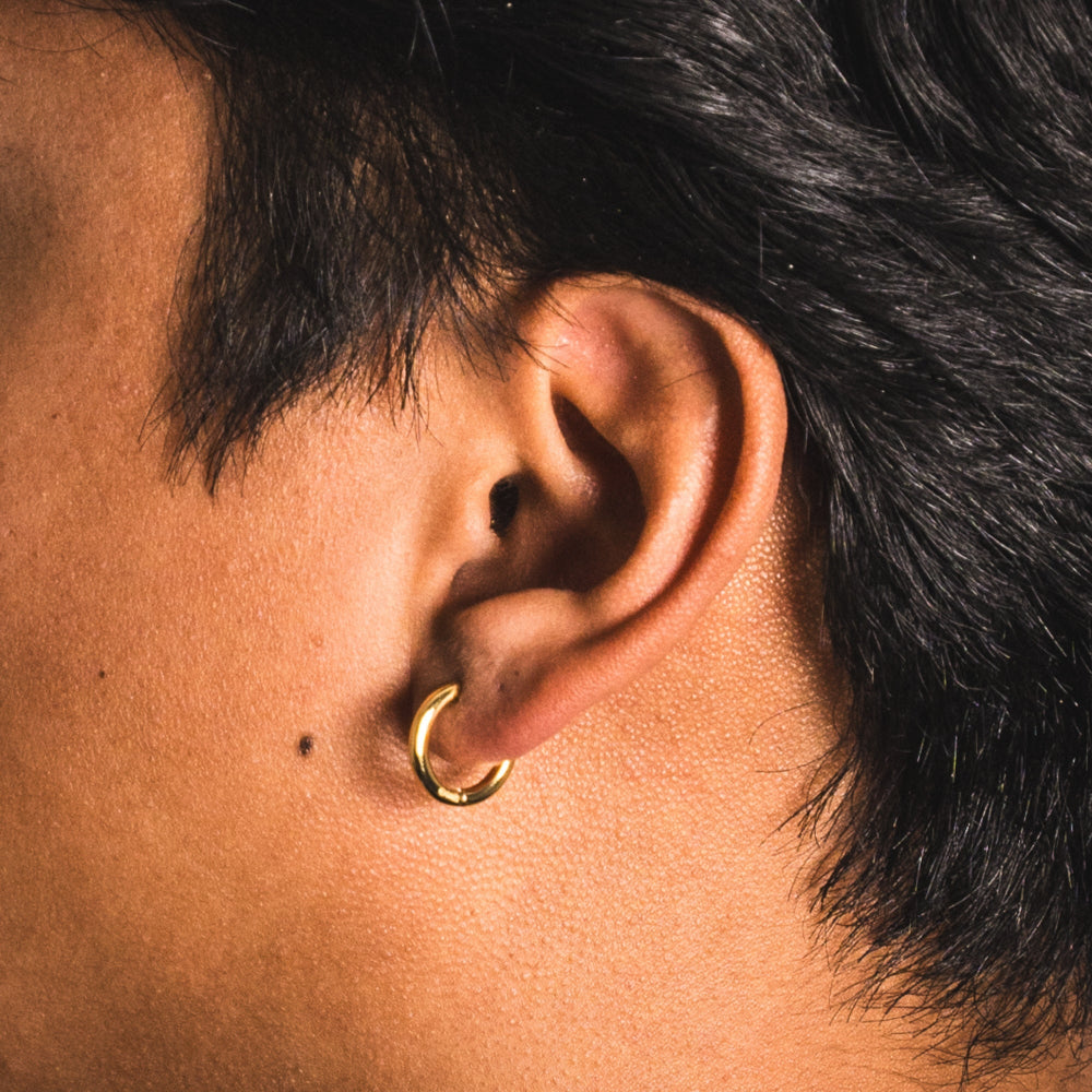 Close-up of an ear with a gold hoop earring