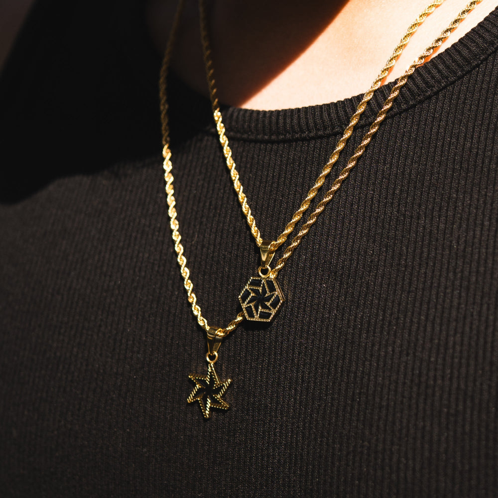 Two gold necklaces with geometric pendants on a black background