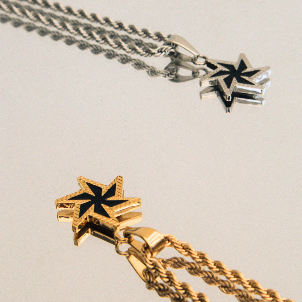 Two star-shaped pendants on chains against a neutral background
