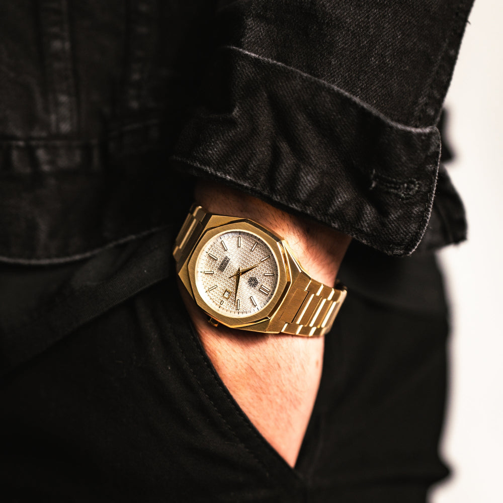 Gold wristwatch on a person's wrist with a blurred background