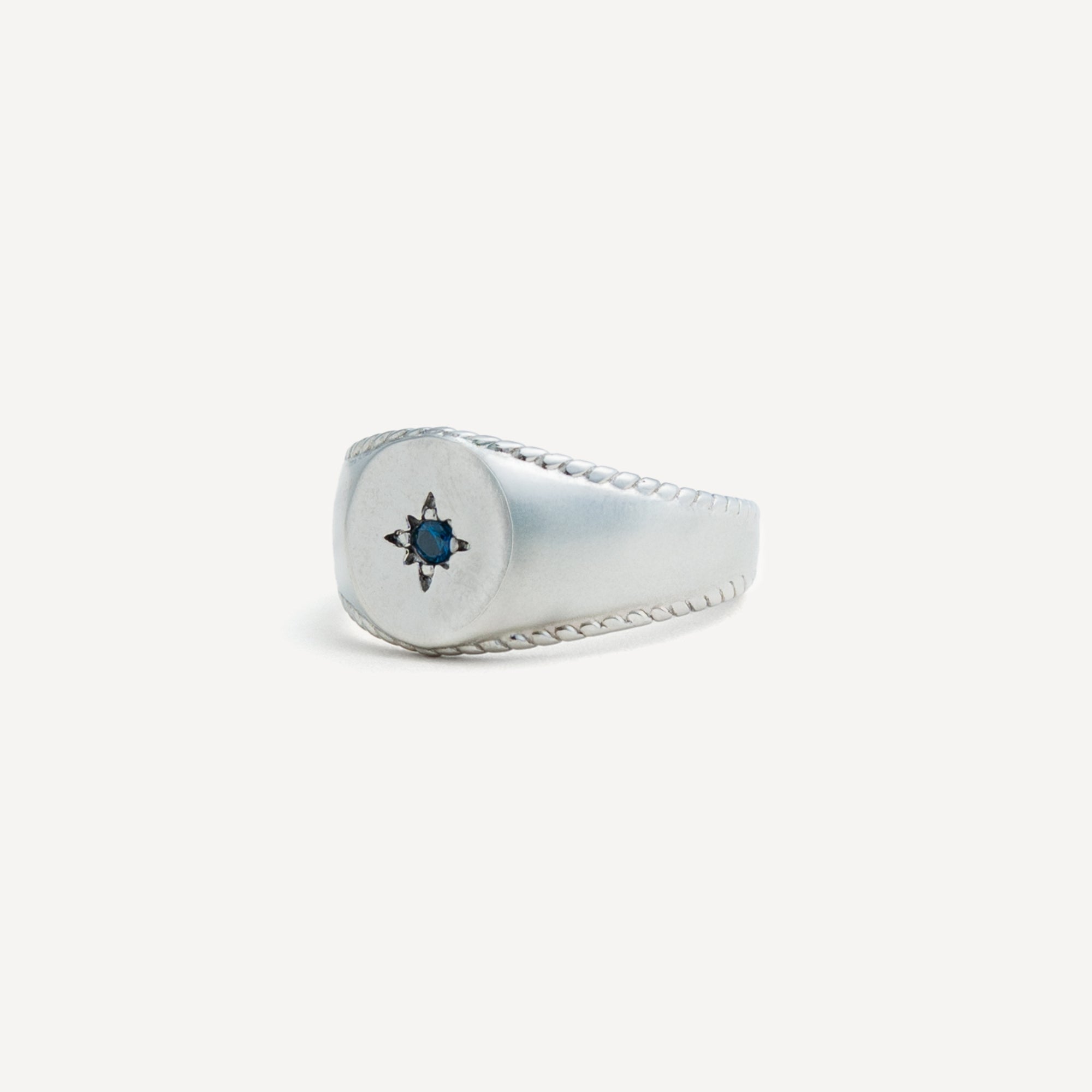 Silver ring with a blue gemstone on a white background