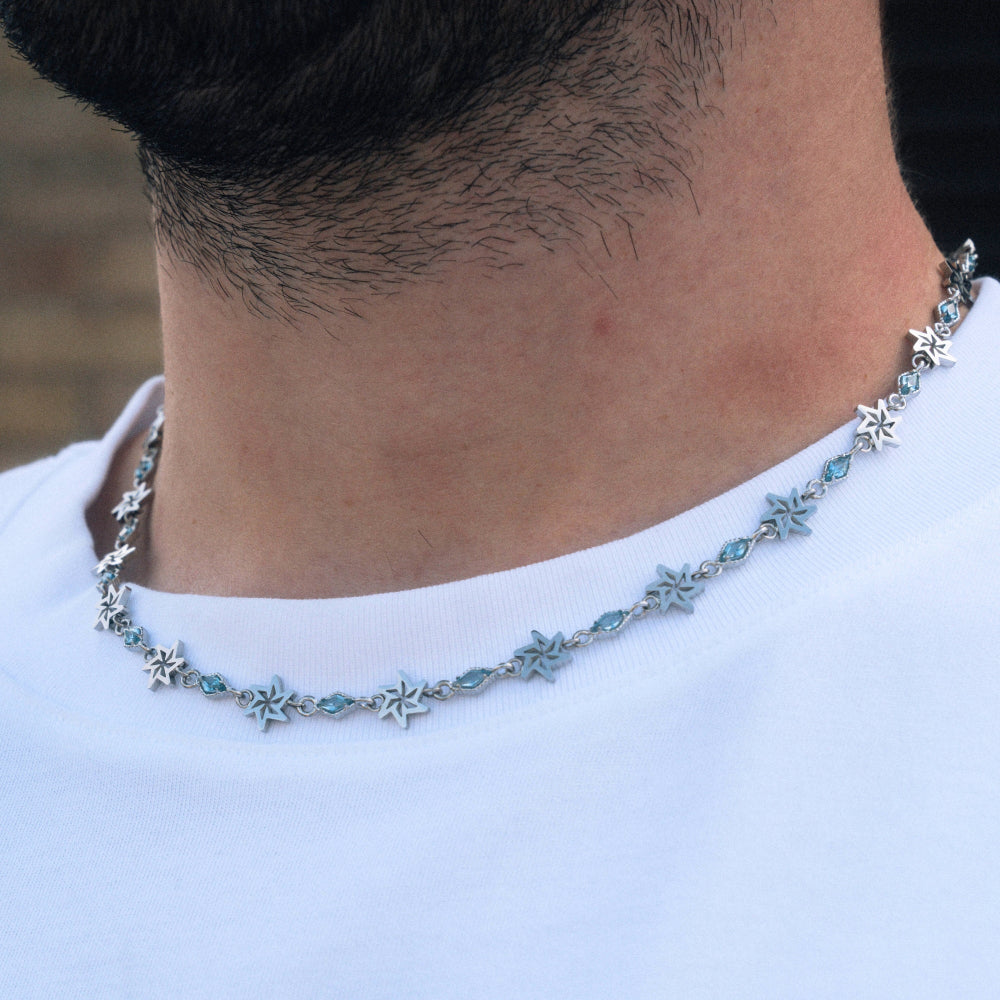 Necklace with star-shaped pendants worn by a person on a blurred background