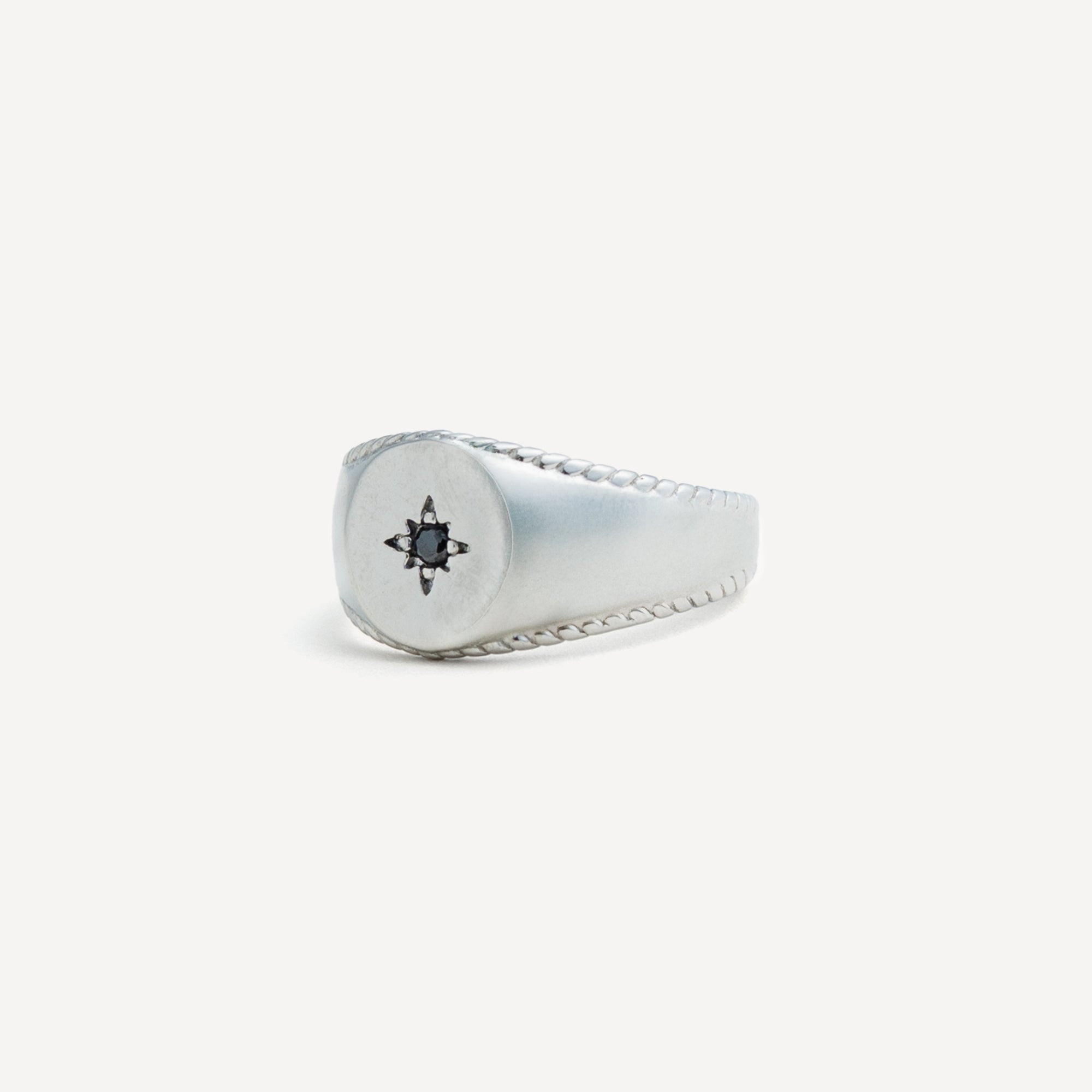 Silver ring with a star design on a white background
