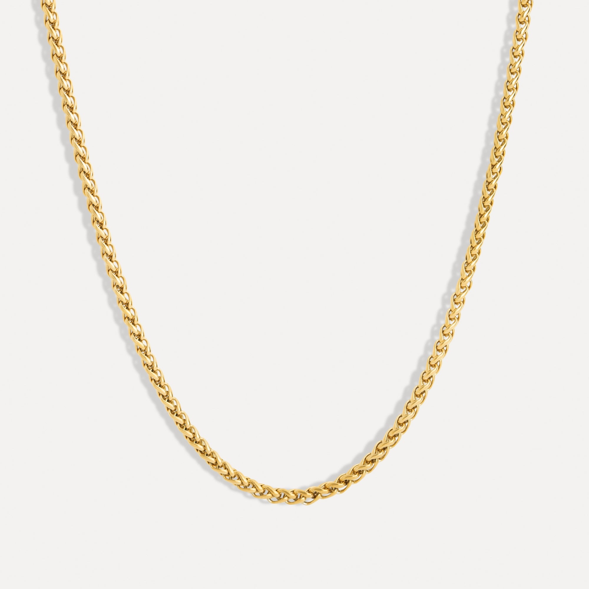 Gold chain necklace on a light gray background