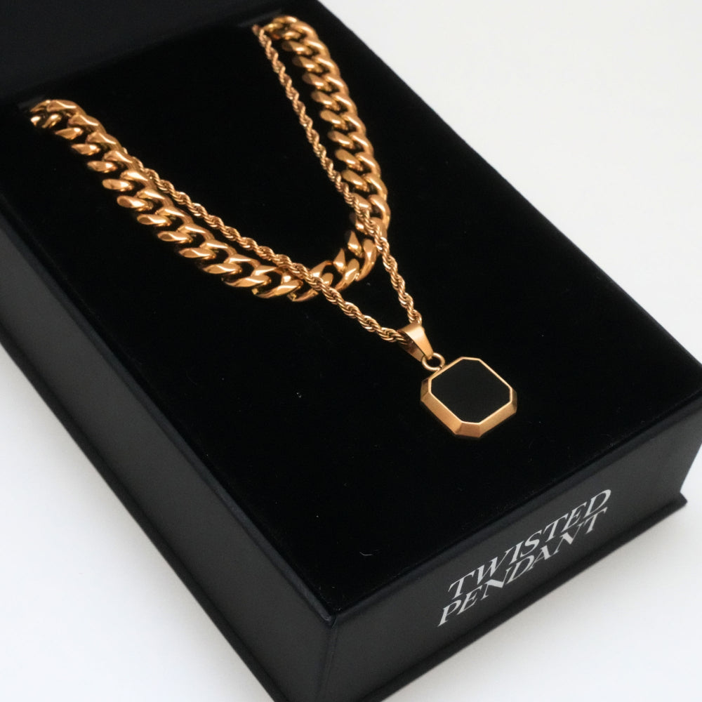 Gold chain necklace with a twisted pendant on a black box labeled 'Twisted Pendant'.